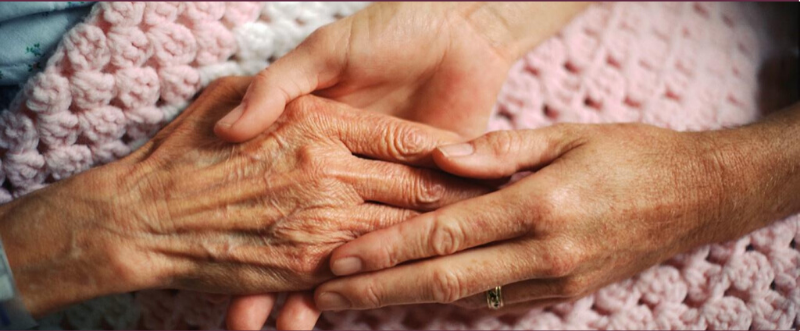 Image of two people holding hands.